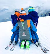 Des enfants font des câlins à un moniteur de ski à Limone après l'un des cours particuliers de ski pour enfants de tous niveaux.