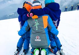 Kids hugging a ski instructor in Limone after one of the Private Kids Ski Lessons for All Levels. 