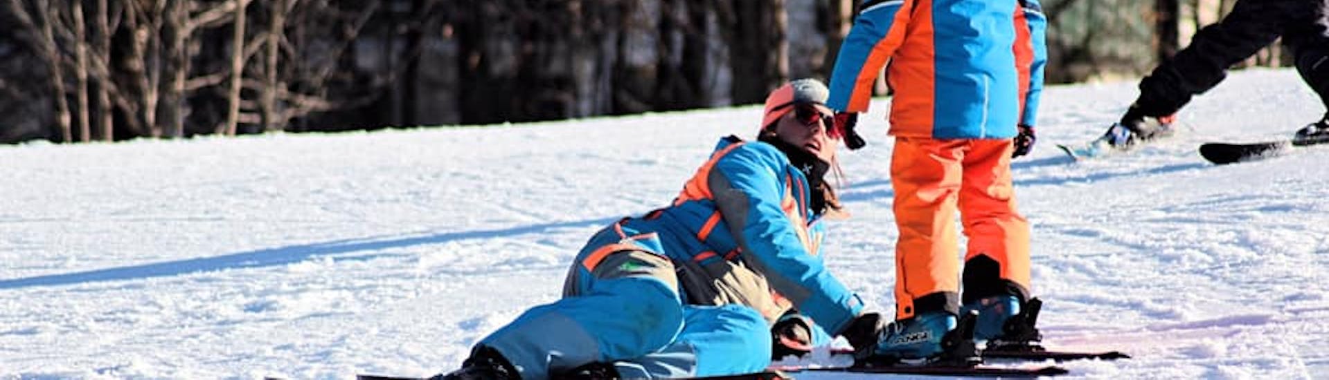 Maestro di sci che segue da vicino un bambino a Limone durante una delle lezioni private di sci per bambini di tutti i livelli.