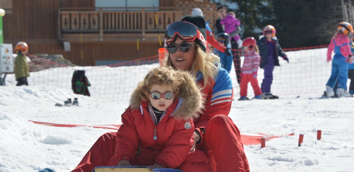 An ESF Courchevel 1650 instructor has fun with a little skier during a Mini-Piou kids ski lesson.