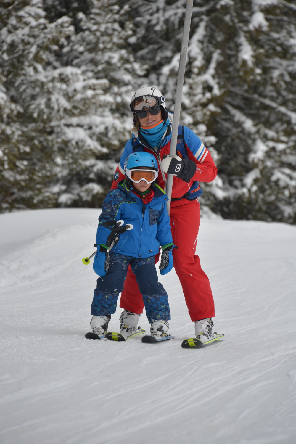 Un moniteur de l'ESF Courchevel 1650 guide un enfant lors de ses premiers pas à ski lors d'un cours de ski enfants au Club Piou-Piou.