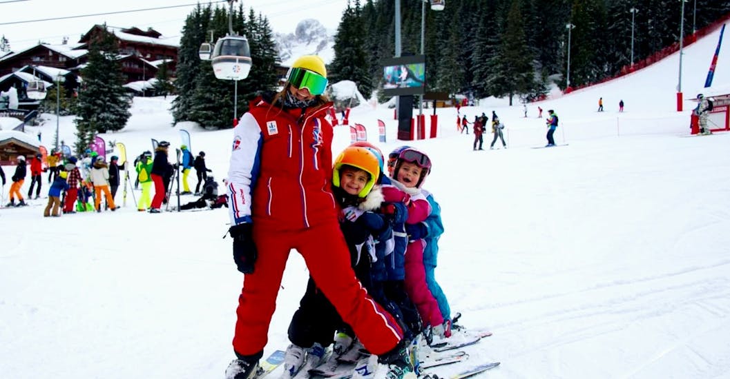 Children having fun with their ESF Courchevel instructor during a kids ski lesson at Club Piou-Piou.