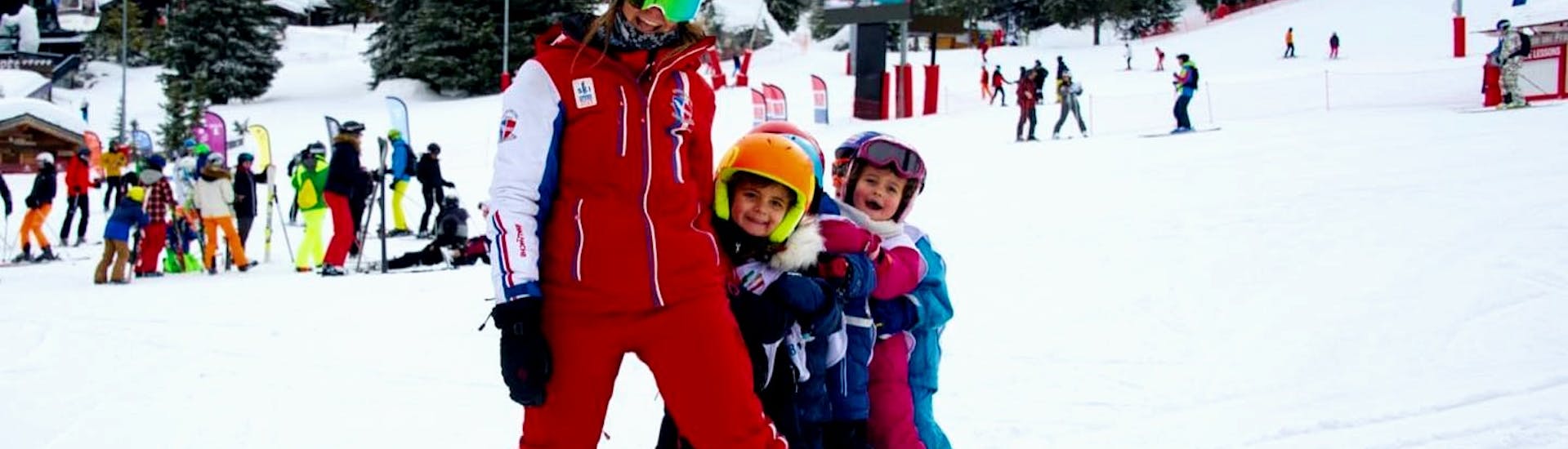 Children having fun with their ESF Courchevel instructor during a kids ski lesson at Club Piou-Piou. 
