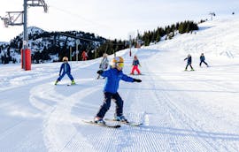 Kids are skiing down a slope during their  Kids Ski Lessons (6-12 y.) with ESF Courchevel 1650 - Moriond.