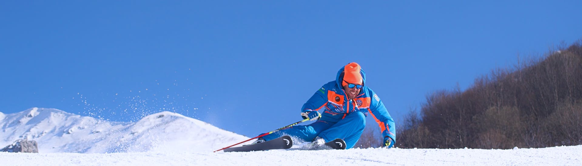 Ski instructor racing at full speed on the snow of Limone before one of the private Adults Ski Lessons for All Levels.