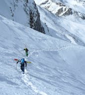 Des participants escaladent la montagne dans la neige fraîche à Limone pendant l'un des cours particuliers de ski Freeride.