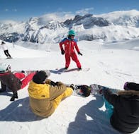 Ein Lehrer der ESF Courchevel 1650 erklärt die Grundlagen des Snowboardens während einer Snowboardstunde für alle Levels.