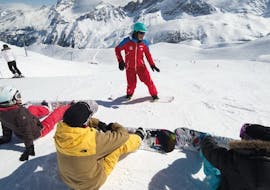An instructor from the ESF Courchevel 1650 explains the basics of snowboarding during a snowboarding lesson for all levels.