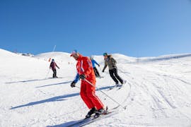 Skifahrer folgen ihrem Skilehrer die Piste hinunter, während sie mit ESF Courchevel 1650 - Moriond Privatunterricht für Erwachsene für alle Levels nehmen.