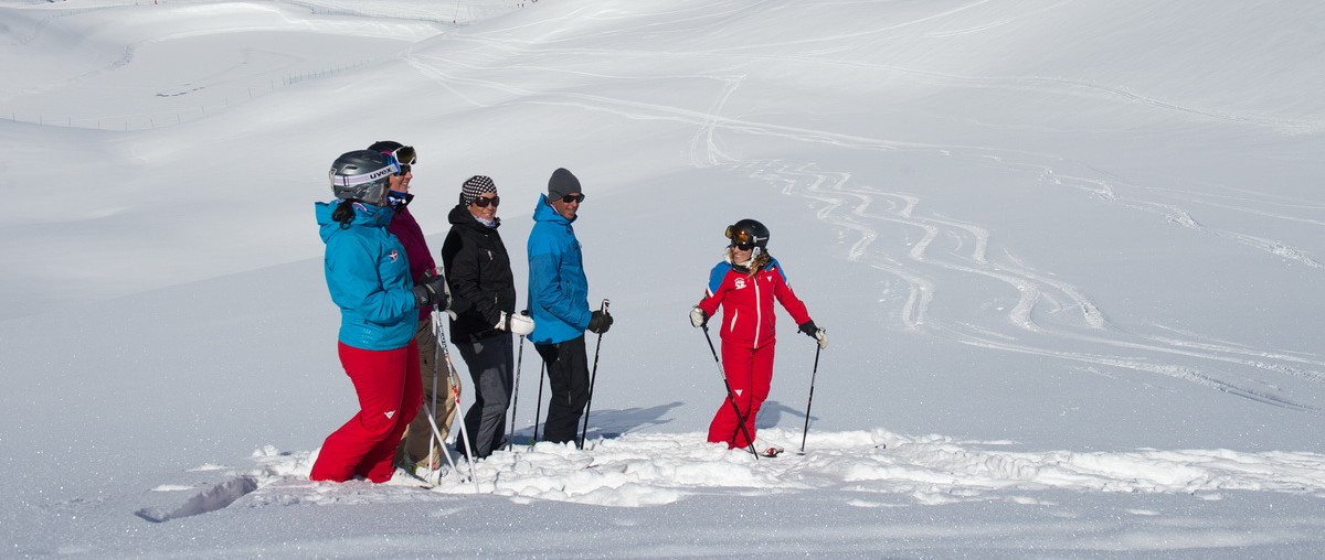 Une monitrice de l'ESF Courchevel 1650 et un groupe de skieurs durant un cours particulier de ski pour adultes.