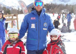 Two happy kids with their instructor during the kids ski lessons with Scuola di Sci Monti della Luna San Sicario.
