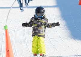 Ein kleiner Skifahrer macht seine ersten Schritte auf Skiern im Kinderland bei der Skischule Snowstars Turracher Höhe.