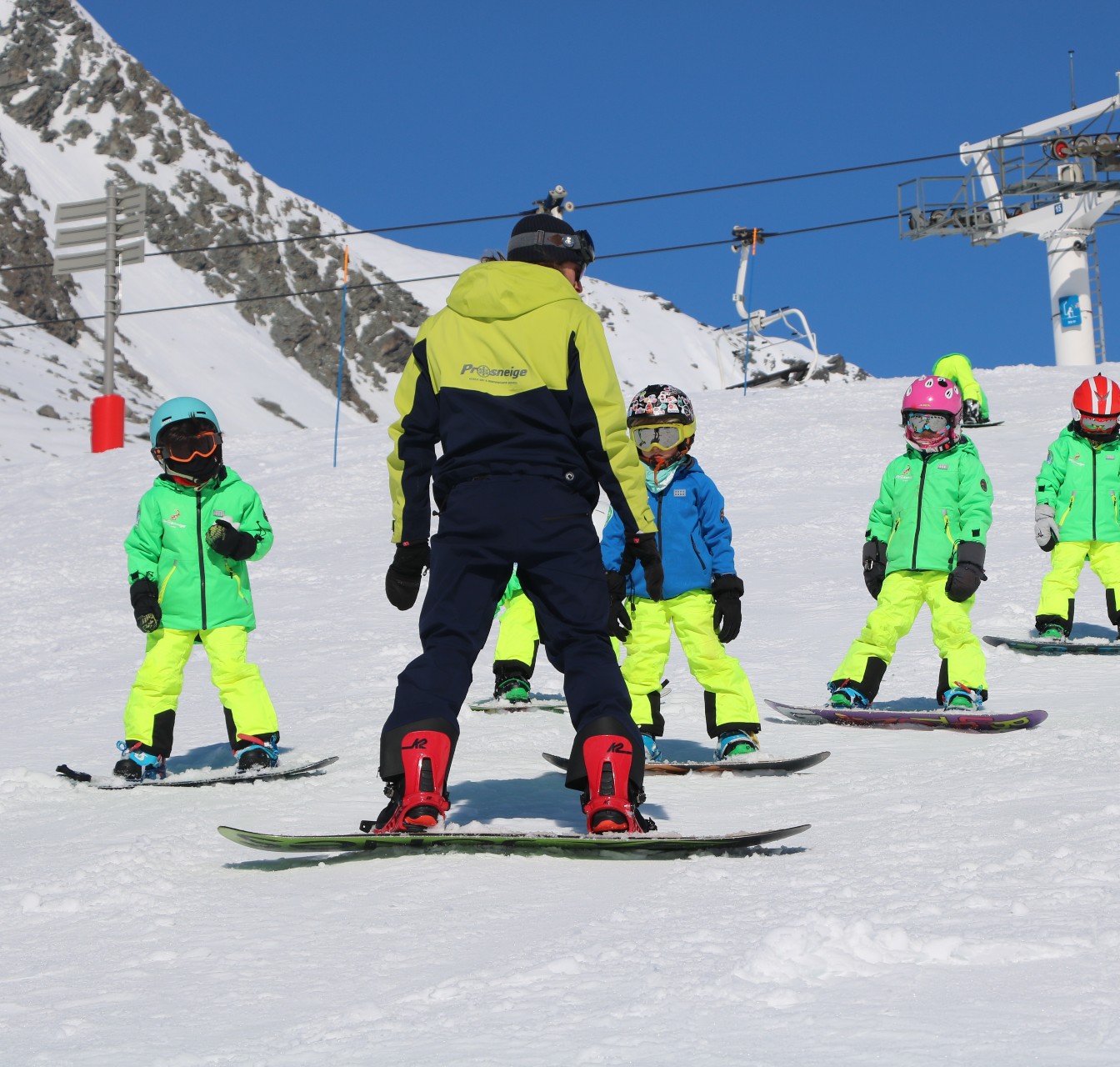 Un moniteur enseigne le snowboard pendant un cours de snowboard avec Prosneige Tignes. 