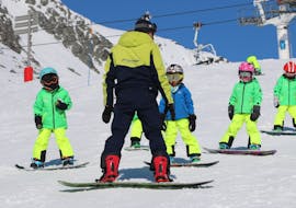 An instructor teaches snowboarding during a snowboarding lesson with Prosneige Tignes. 