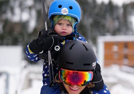 Ein Kind posiert vor der Kamera mit seinem Skilehrer während des Privaten Kinder-Skikurses für alle Levels mit der Skischule SNOWSTARS Turracher Höhe.