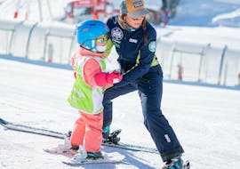 Un moniteur aide un enfant à trouver son équilibre pendant un Cours particulier de ski pour Enfants avec Prosneige Tignes.