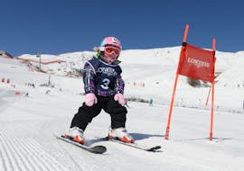Ein kleines Mädchen lernt im privaten Kinderskikurs der Schweizer Skischule St. Moritz the Red Legends das Slalomfahren.