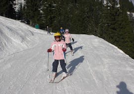 A group of children going down the slopes during their Private Ski Lessons for Kids of All Ages and Levels with Skischule Alpin-Profis Kirchberg/Tirol.
