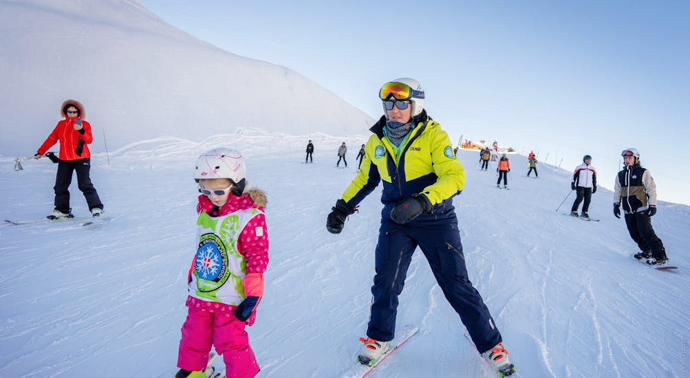 A kid is skiing down a slope in confidence thanks to her Private Ski Lessons for Kids & Teens of All Ages with Prosneige Alpe d'Huez.