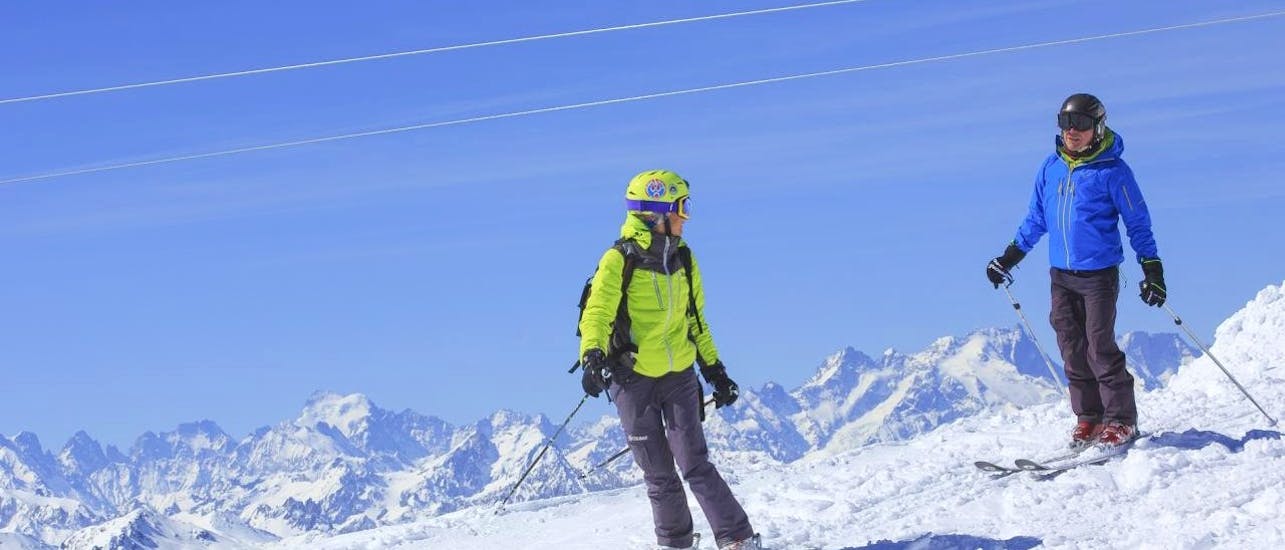 Un skieur skie avec son moniteur pendant un Cours particulier de ski Adultes avec Prosneige Alpe d'Huez.