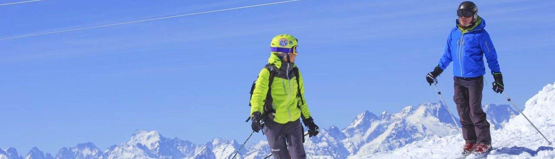 Un skieur skie avec son moniteur pendant un Cours particulier de ski Adultes avec Prosneige Alpe d'Huez.