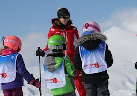 An instructor of the Ski School ESF Valmorel supervises young skiers during kids ski lessons. 