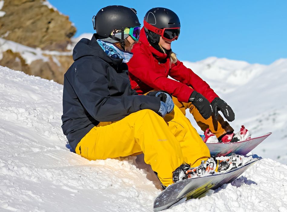 Two snowboarders take a break during their snowboarding lessons for all levels with the Ski School ESF Valmorel.