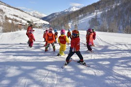 Kinder und Skilehrer in Pragelato für einen der Kinderskikurse für Anfänger. 