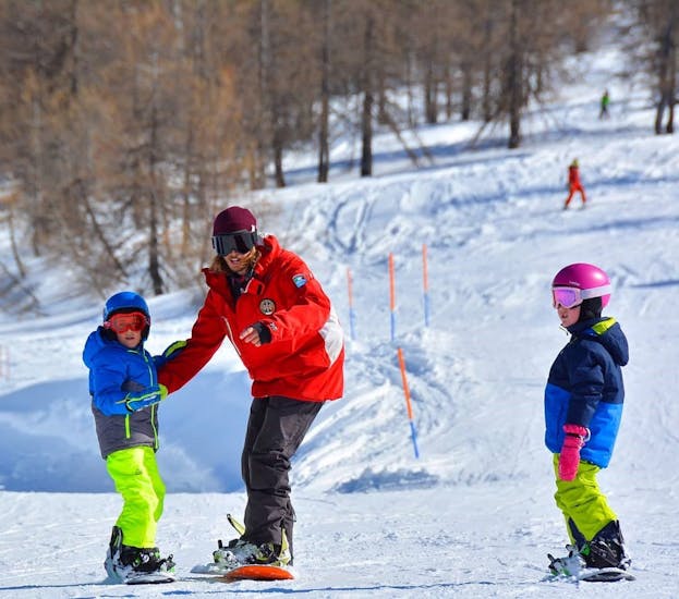 Picture of two kids during the Kids Snowboarding Lessons (5-15 y.) for Beginners.