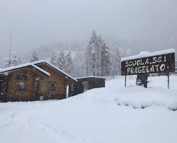 Photo étonnante de l'école de ski couverte de neige à Pragelato. Environnement parfait pour un des cours particuliers de ski pour adultes de tous niveaux.