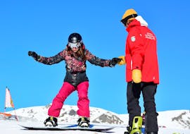 Snowboardleraar geeft tips aan een deelnemer in Pragelato tijdens een van de privé snowboardlessen voor volwassenen van alle niveaus.