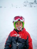 Un bambino felice sulla neve durante la lezione di sci per bambini all'Immacolata con Scuola di Sci Ponte di Legno.