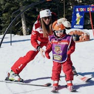 Ein junger Skifahrer macht seine ersten Schritte während des "Club Piou Piou"-Kinderskikurses mit einem Skilehrer der ESF Serre Chevalier - Villeneuve.