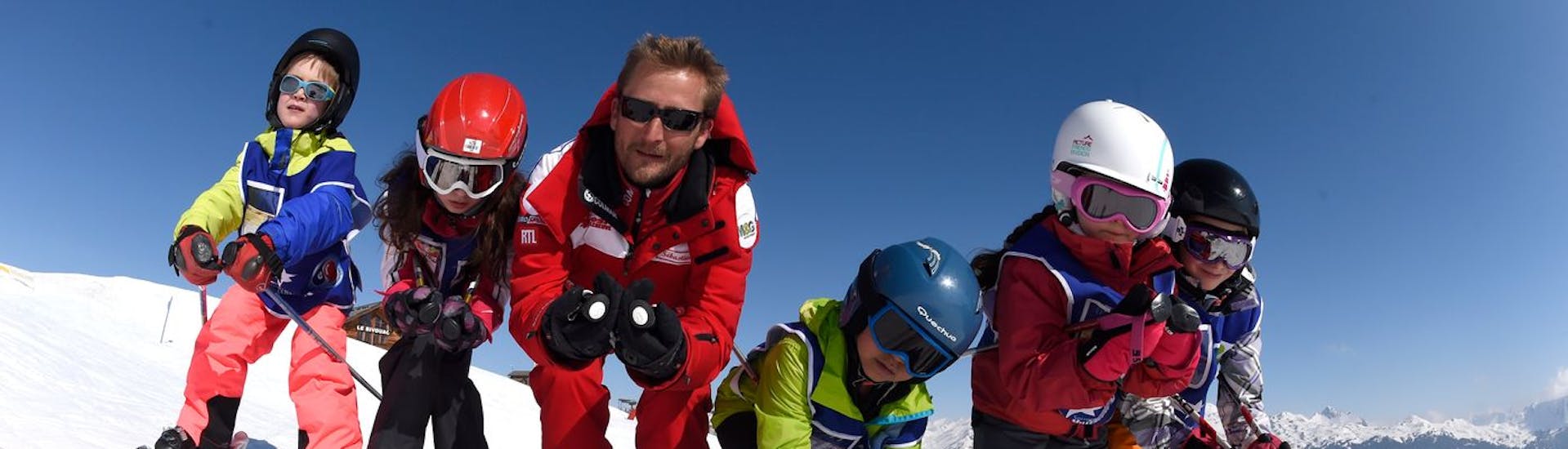 Des enfants et leur moniteur de l'ESF Serre Chevalier - Villeneuve pratiquent le schuss pendant les cours de ski Enfants "Flocon" pour débutants.