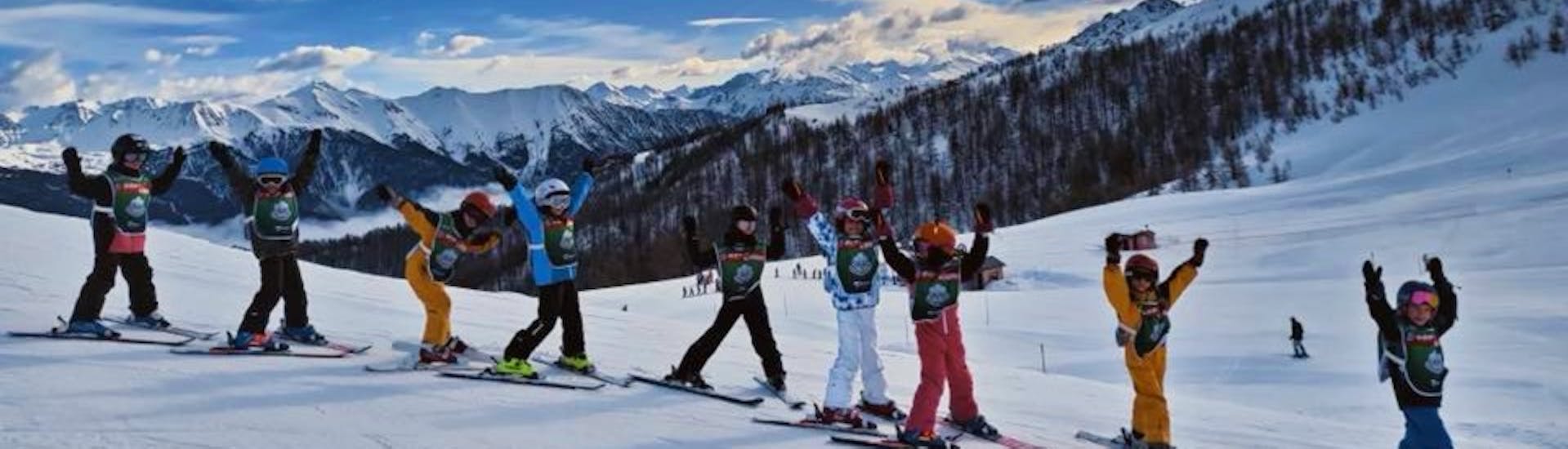 Skiers follow their instructor on the slopes of Serre Chevalier Villeneuve during kids ski lessons for intermediate skiers with the ski school ESF.
