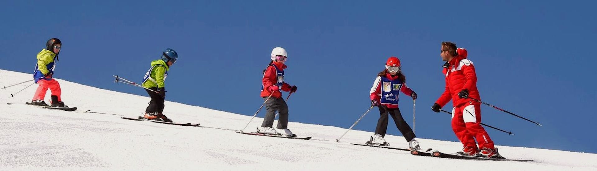 Des enfants et leur moniteur de l'ESF Serre Chevalier- Villeneuve sur les pistes pendant des cours de ski enfants max 6 élèves par groupe.