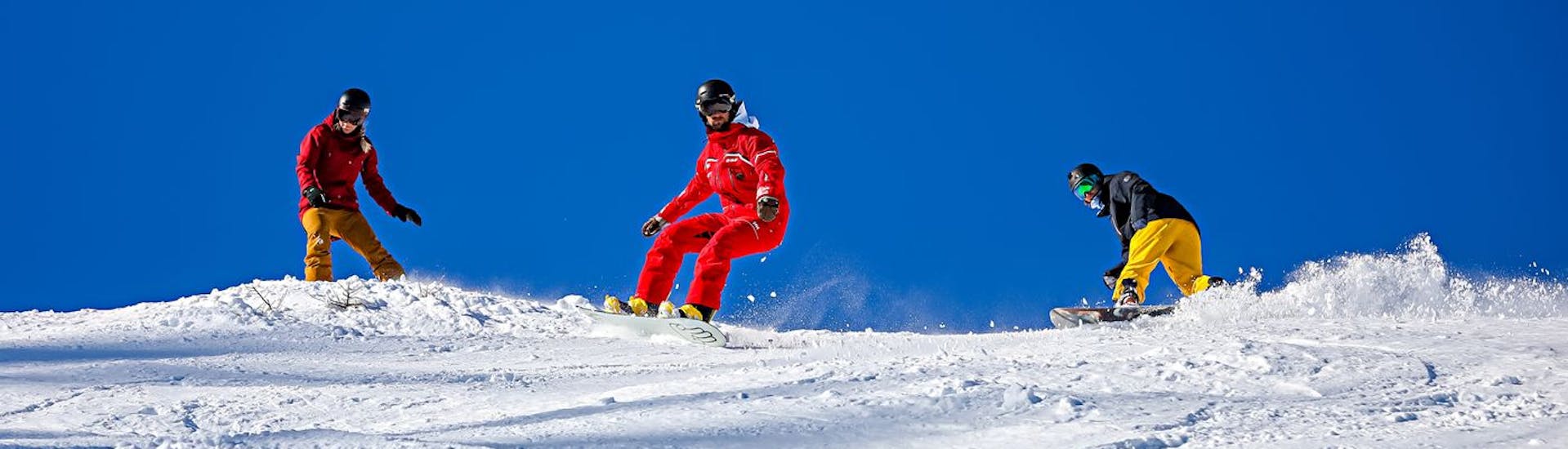 A snowboard instructor makes turns on the slopes during snowboarding lessons from 9 years old with the Ski School ESF Serre Chevalier - Villeneuve.