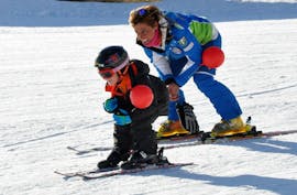 Kid and ski instructor are having fun playing in Roccaraso during one of the private kid ski lessons for all levels.