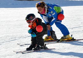 Kid and ski instructor are having fun playing in Roccaraso during one of the private kid ski lessons for all levels. 