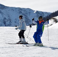 Partecipante e maestro di sci che provano la prima pista blu durante una delle lezioni private di sci per adulti per tutti i livelli.