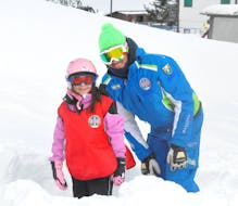 Snowboard instructor and kid smiling at the camera in Roccaraso during one of the private snowboarding lessons for kids and adults of all levels.