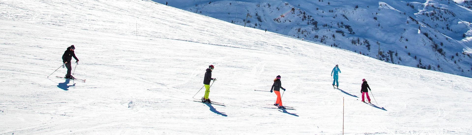 Des skieurs et leur moniteur de l'ESI Ski Family descendent les pistes de Chamonix pendant un cours de ski adultes pour tous niveaux. 