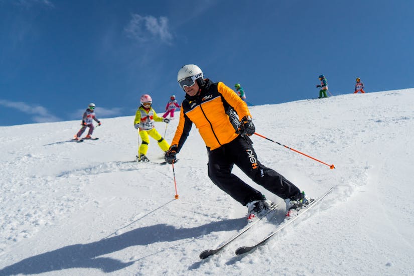 An instructor going down the slopes followed by children during Kids Ski Lessons - Half Day with HSKI Zakopane.