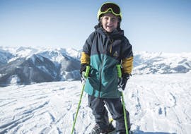 A little skier smiles at the camera during his private kids ski lessons with the OnSki ski school in Saalbach-Hinterglemm.