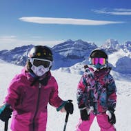 Two kids have fun while learning how to ski during a lesson in Astún with FreeXDay.