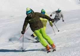 Un moniteur de ski dévale les pentes pendant un cours particulier de ski pour adultes de tous niveaux à Astún avec l'école de ski FreeXDay.