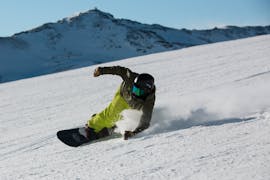 A snowboarder goes downhill during an adult snowboarding lesson for all levels in Astún with FreeXDay ski school.