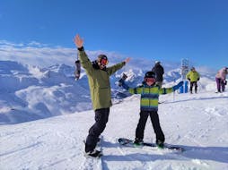 Un moniteur privé et un enfant partent pour un cours particulier de snowboard pour enfants et adultes de tous niveaux à Astún avec l'école de ski FreeXDay.