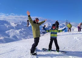 Een privéleraar en een kind nemen deel aan een privé snowboardles voor kinderen & volwassenen van alle niveaus in Astún met skischool FreeXDay.