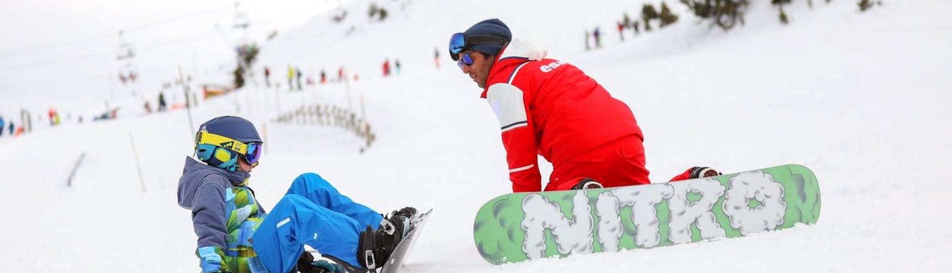 Un moniteur et son élève se repose pendant un cours particulier de snowboard avec l'ESF d'Abriès Haut-Guil. 
